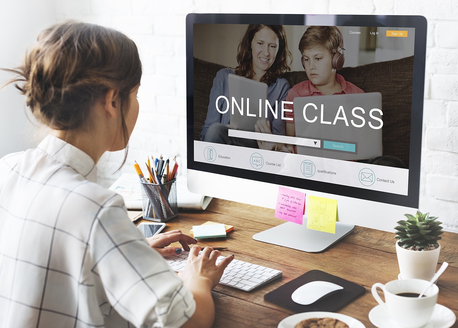 Image of a person sitting in front of a computer monitor that has the text "Online Class" on the screen.